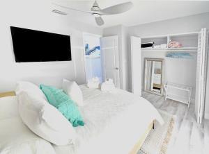 a bedroom with a white bed with a ceiling fan at Waterfront l Private Pool l Dock l Sunset Views in St Petersburg +45 photos