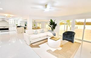 a white living room with a white couch and a table at Waterfront l Private Pool l Dock l Sunset Views in St Petersburg