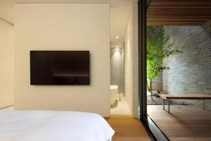 a bedroom with a flat screen tv on the wall at Namu Hotel in Seoul