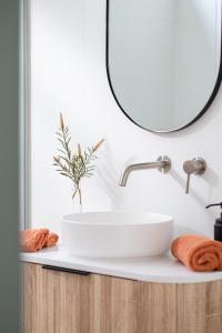 a bathroom with a sink and a mirror at White Beach Retreat - Luxury With Water Views in White Beach
