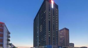 a tall building with a red light on top of it at Echarm Hotel Yantai Wuzhou International in Yantai