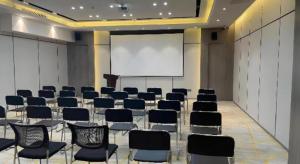 a conference room with chairs and a white screen at Echarm Hotel Yantai Wuzhou International in Yantai