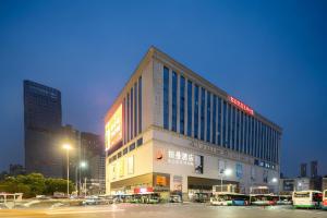 a large building in a city at night at Borrman Hotel Wuhan Hankou Railway Station Metro Station in Wuhan