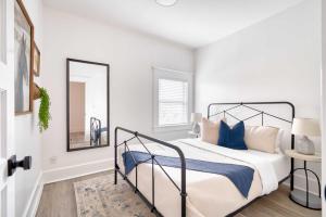 une chambre avec un lit avec des oreillers bleus et un miroir dans l'établissement Stay Portland - Soul District Mansion - Food Carts & Local Shops, à Portland 50 autres photos