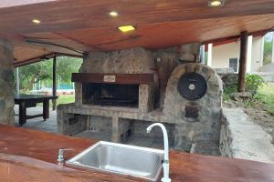 a kitchen with a stone oven with a sink at Vado Biguá in Valle Hermoso +43 photos