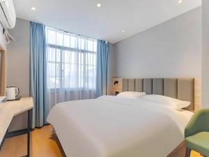 a bedroom with a large white bed and a window at Shell Hotel Hefei Provincial Hospital in Hefei