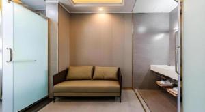 a chair in a bathroom with a sink at GELI Kunming North Railway Station Zoo in Kunming +79 photos