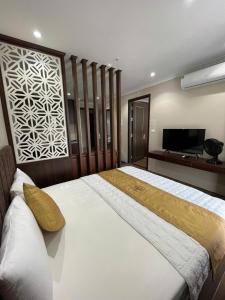 a bedroom with a large bed and a flat screen tv at Khách Sạn Á Châu in Trại Khao