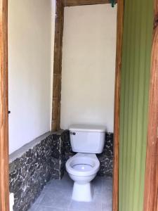 a bathroom with a white toilet in a room at Hostal Tierra de Nubes in Melgar