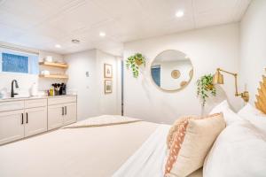 a white bedroom with a large bed and a mirror at Stay Portland - Budget-Friendly Basement Hideaway - 91 WalkScore in Portland