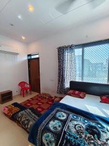 a bedroom with a bed and a large window at Aasha Palace Khatu Shyam Ji in Khātu +23 photos