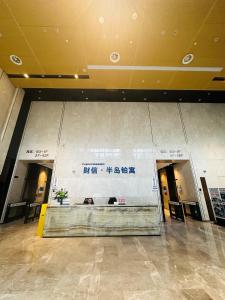 a lobby with a large wall with writing on it at Chongqing Justom Family Serviced Apartments 2 in Chongqing