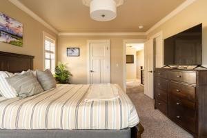 a bedroom with a bed and a flat screen tv at Stay Portland - The Garfield Getaway House- Luxury New Build in Portland +27 photos