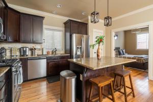 a kitchen with wooden cabinets and a island with stools at Garfield 2BR - New Build - Foodie-Friendly Stay in Portland
