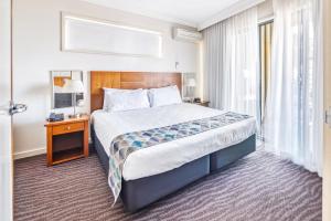 a hotel room with a large bed and a window at Bayside Geelong Hotel & Apartments, an Ascend Collection Hotel in Geelong