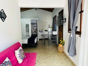 een woonkamer met een roze bank en een slaapkamer bij Aloja-T en Apartaloft amoblado en Jericó in Jericó