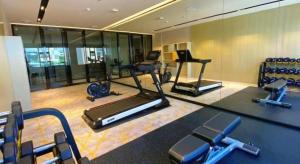 - une salle de sport avec plusieurs vélos d'exercice et un miroir dans l'établissement Echarm Hotel Shenzhen World Exhibition and Convention Center, à Fenghuangwei