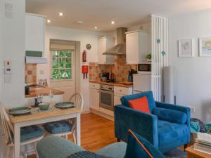 a kitchen with a blue couch and a blue chair at Kingfisher Cottage, 20 in Camelford