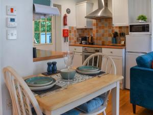 a kitchen with a wooden table with plates on it at Kingfisher Cottage, 20 in Camelford