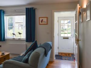 a living room with a couch and a window at Kingfisher Cottage, 20 in Camelford