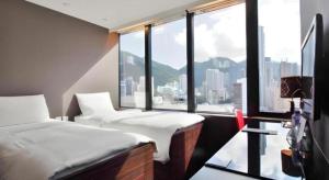 Una habitación de hotel con dos camas y una gran ventana. en J Link Hotel, en Hong Kong