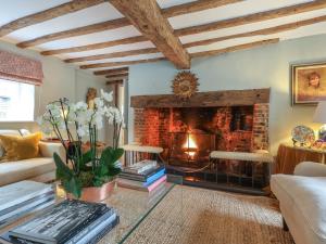 a living room with a fireplace and a couch at Lynchets Cottage in Lambourn