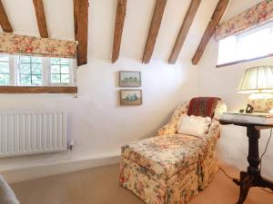 a room with a chair and a table with a lamp at Lynchets Cottage in Lambourn +22 photos