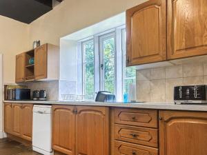 a kitchen with wooden cabinets and a window at High Rylands in Arncliffe +34 photos