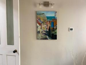 a painting hanging on a wall next to a door at Holme Crest in Staithes