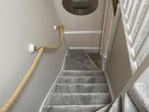 a staircase with a rope attached to the wall at Holme Crest in Staithes