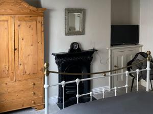 a bedroom with a fireplace and a bed and a mirror at Holme Crest in Staithes +8 photos