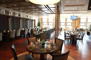 une salle à manger avec des tables, des chaises et une télévision dans l'établissement Chengdu Joyhub Air Hotel, à Chengdu