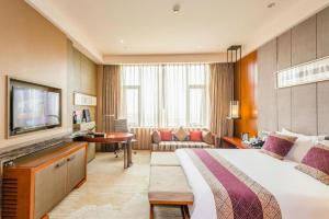 une chambre d'hôtel avec un grand lit et un salon dans l'établissement Chengdu Joyhub Air Hotel, à Chengdu