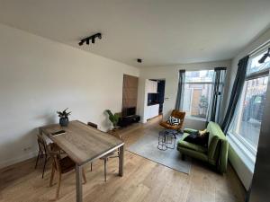 a living room with a wooden table and a green chair at Cozy apartment in Utrecht in Utrecht
