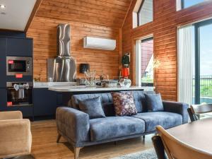 a living room with a blue couch in a kitchen at Briallen - Primrose - Ukc7075 in Mydroilin
