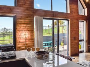 a living room with wooden walls and glass doors at Briallen - Primrose - Ukc7075 in Mydroilin