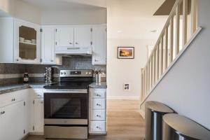 Una cocina con gabinetes blancos y una estufa. en Alphabet District - 2BR Retreat - Prime Locale, en Portland