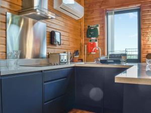 a kitchen with blue cabinets and a sink at Briallen - Primrose - Ukc7075 in Mydroilin