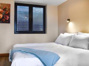 a bedroom with a bed with white sheets and a window at Briallen - Primrose - Ukc7075 in Mydroilin +21 photos