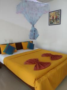 a bedroom with a large bed with yellow sheets at Freedom Home Stay in Sigiriya