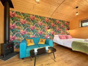 Ein Zimmer mit einer blauen Couch, einem Bett und einem Kamin in der Unterkunft Bets - Ukc7017 in Rug