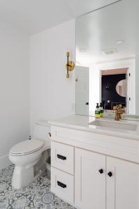 a white bathroom with a toilet and a sink at Stay Portland - Sophisticated 2BR - Prime NW 23rd Location in Portland