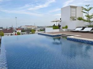 a swimming pool with blue water in front of a building at The Axana Hotel in Kampungdurian