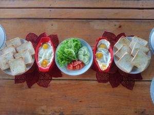 a table topped with sandwiches and a bowl of vegetables at Seahorse Homestay in Pulau Mansuar