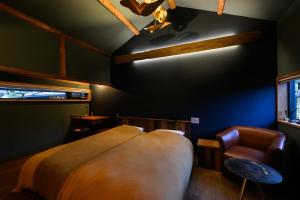 a bedroom with a large bed and a chair at cofunia in Tenri