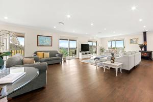 a large living room with couches and a tv at Olive Grove - Pet Friendly with Fireplace in Bellawongarah
