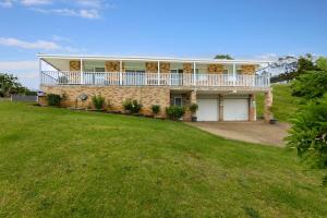 a large brick house with a balcony on it at Olive Grove - Pet Friendly with Fireplace in Bellawongarah