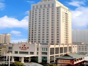 un grand bâtiment blanc avec une enseigne dessus dans l'établissement Yuncheng Jianguo Hotel, à Yuncheng