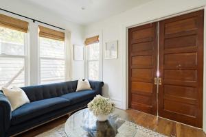 a living room with a blue couch and a glass table at Stay Portland - The Câlin Suite - Posh Local Boutiques & Eateries in Portland