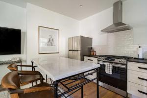 a kitchen with a table and a stove and refrigerator at Stay Portland - The Câlin Suite - Posh Local Boutiques & Eateries in Portland